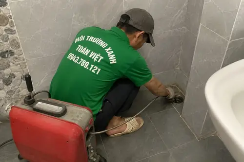 Nhân viên đưa dây máy tại góc phòng vệ sinh.