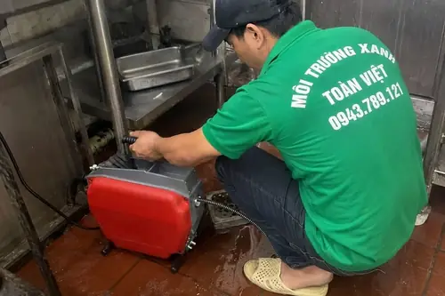 Nhân viên đặt máy lò xo dưới khu chậu rửa.