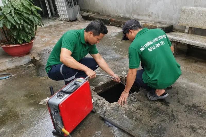 Hai thợ Toàn Việt vận hành máy thông tại hố ga ngoài sân – minh họa thông cống nghẹt Châu Thành A
