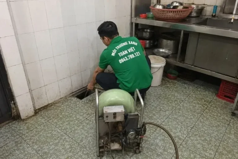 Nhân viên dùng máy xanh tại đường thoát dưới bàn bếp