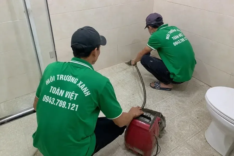 Hai nhân viên đối chiếu điểm thoát trong phòng tắm