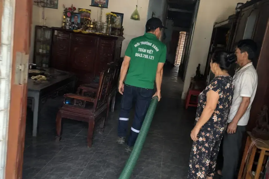 Nhân viên mang ống hút màu xanh qua phòng trong nhà