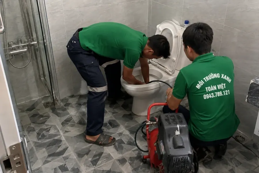 Thông bồn cầu Thuận An giá rẻ uy tín | Toàn Việt 28 Hai nhân viên phối hợp đưa dây vào bồn cầu